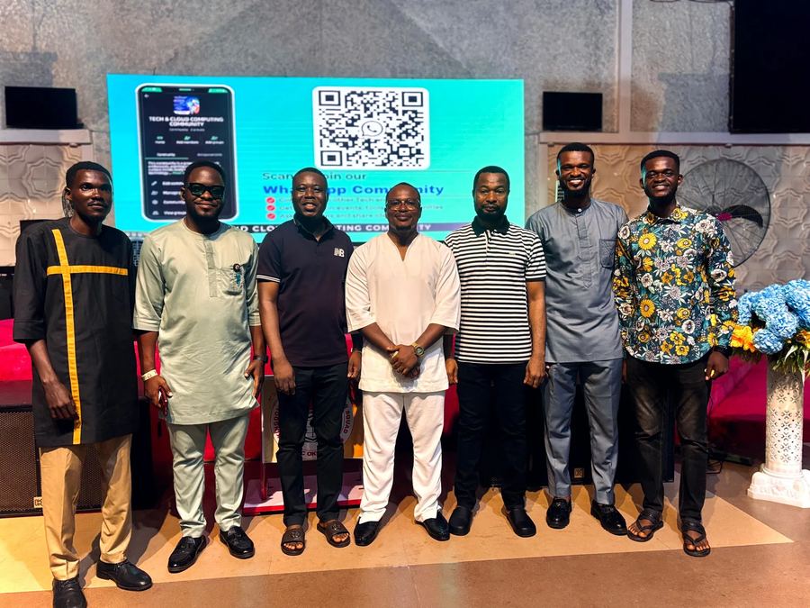Organizers and speakers posing together in front of the WhatsApp community QR code screen