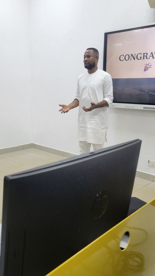 CloudTech Tribe facilitator addressing the class beside a presentation screen
